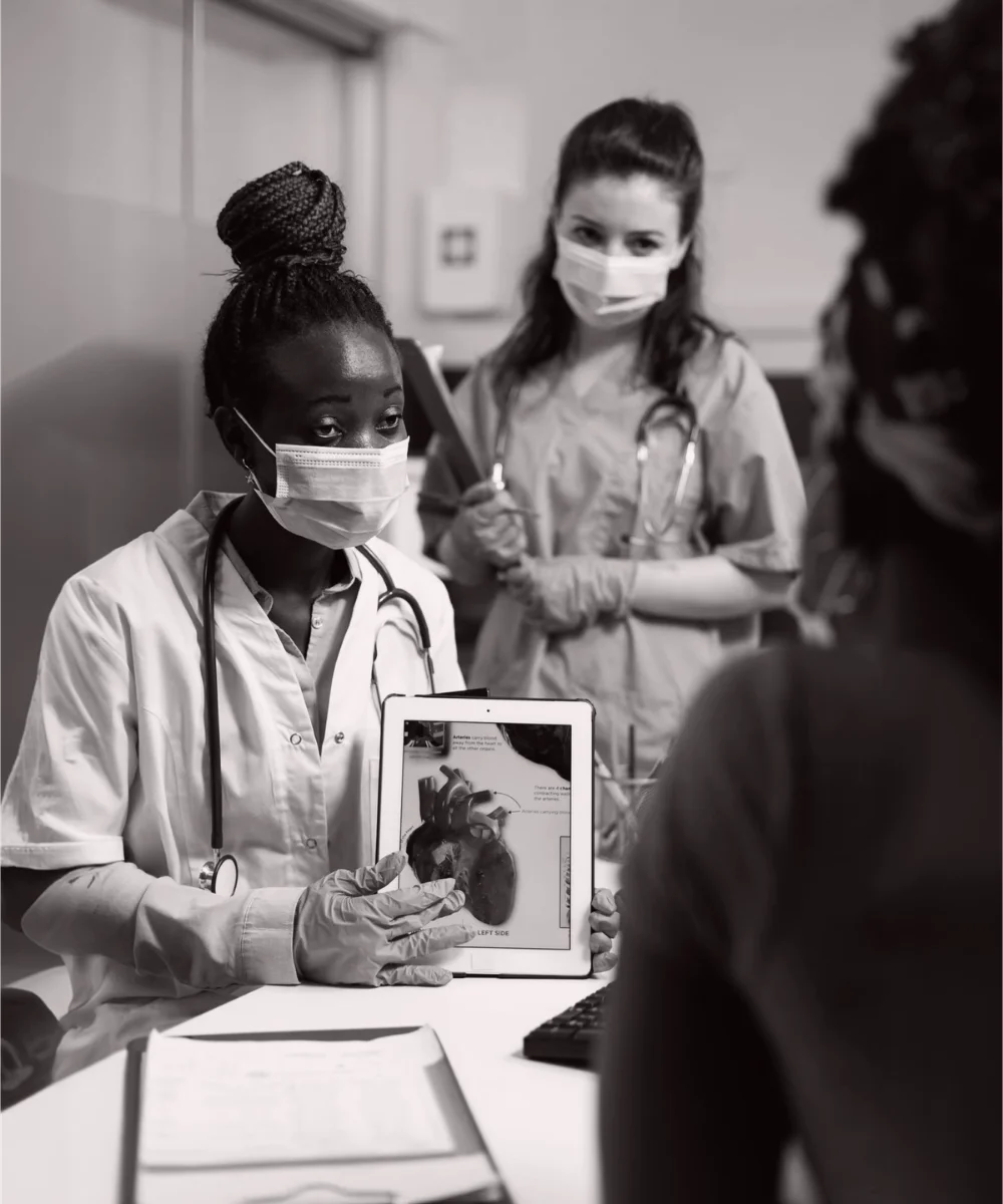 Cardiologist doctor holding tablet showing heart radiography to sick patient