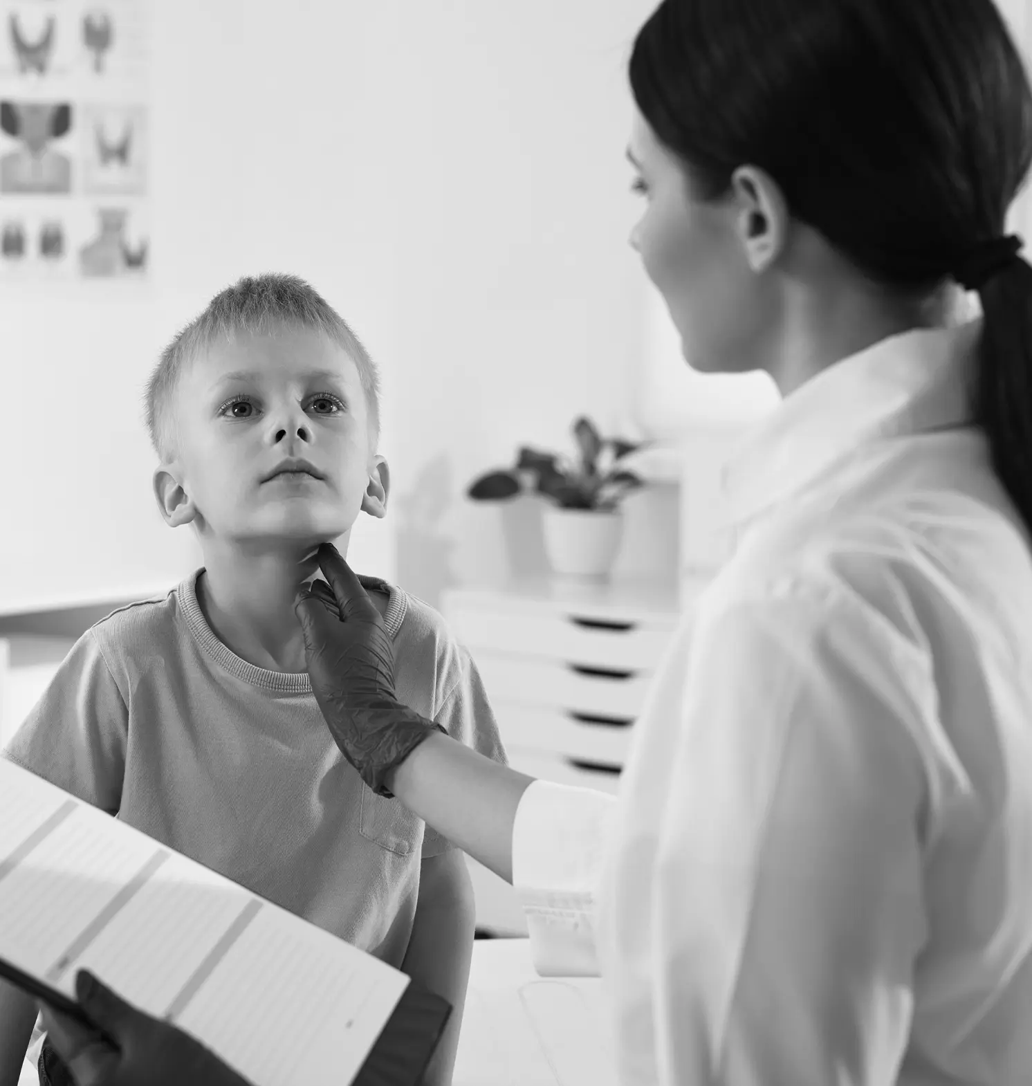 endocrinologist performing a thyroid exam on a child