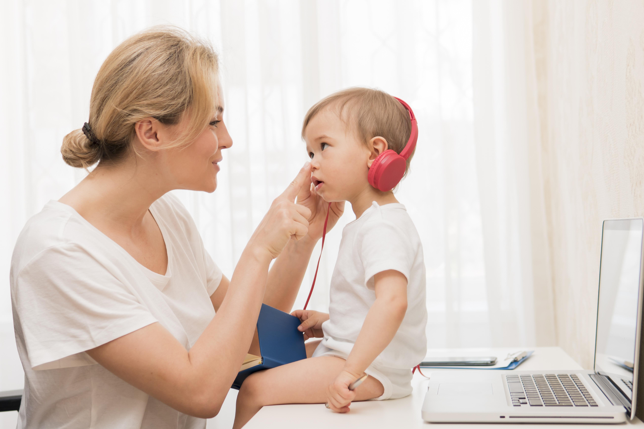 mid-shot-baby-desk-with-headphones-mother-smiling