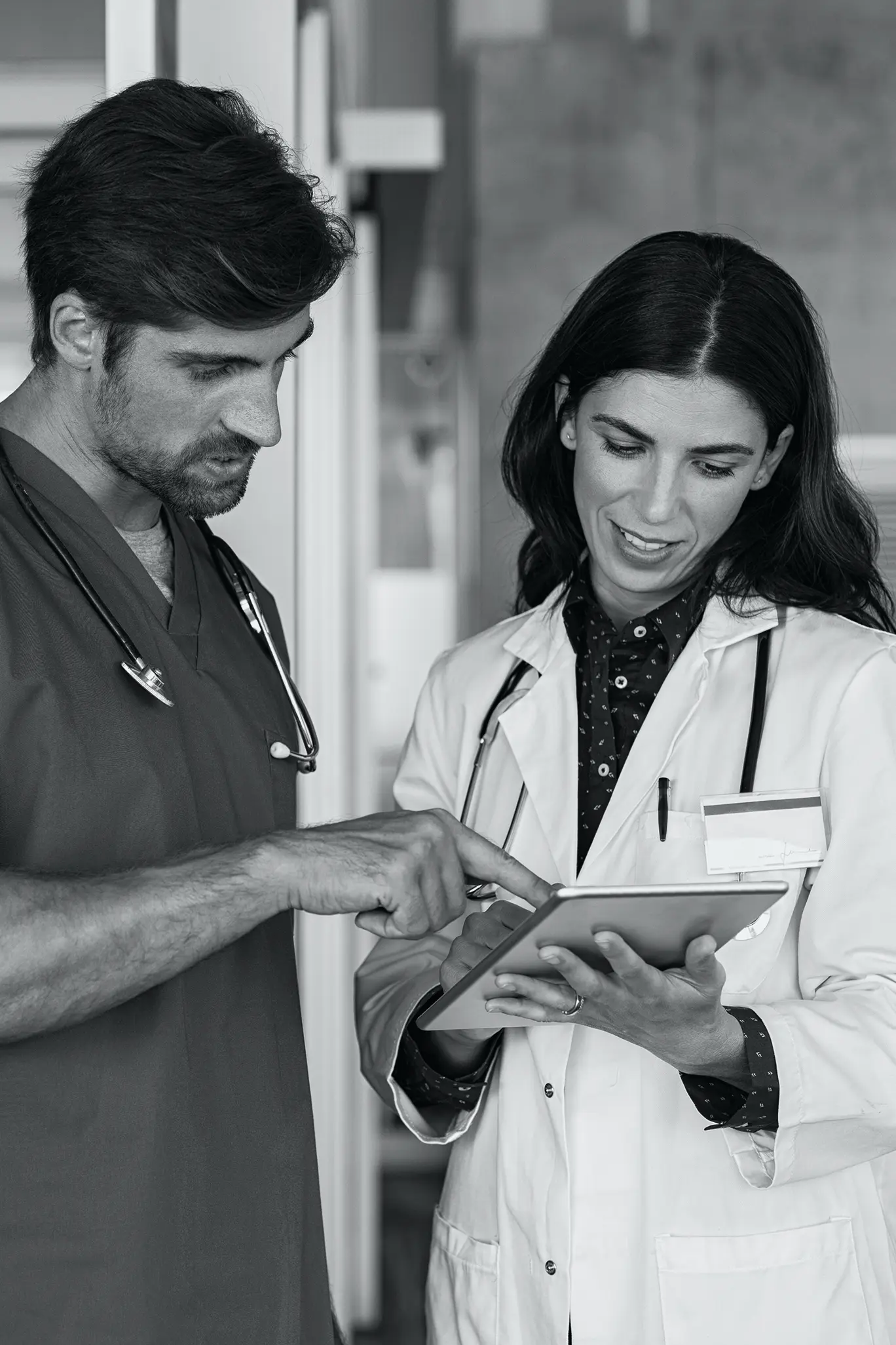 Doctor and nurse looking at patients charts on tablet
