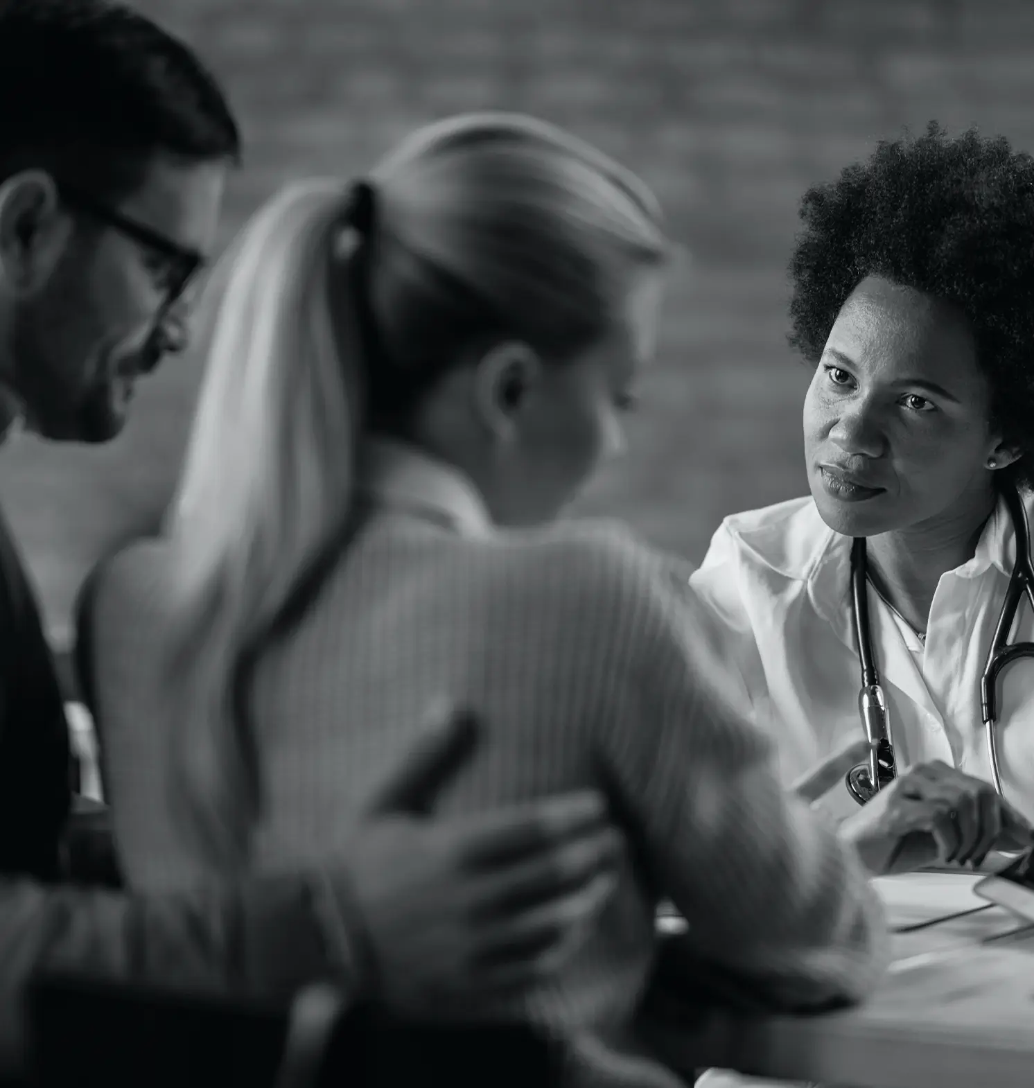a female doctor showing couple their electronic medical record touchpad